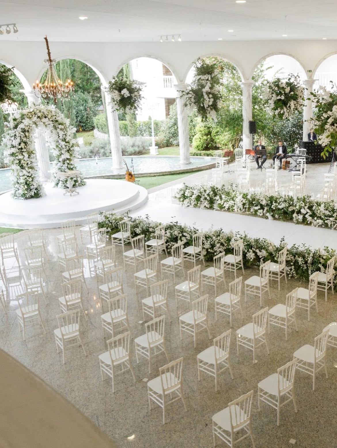Cerimônia de casamento ao ar livre com arco de flores brancas e cadeiras Tiffany