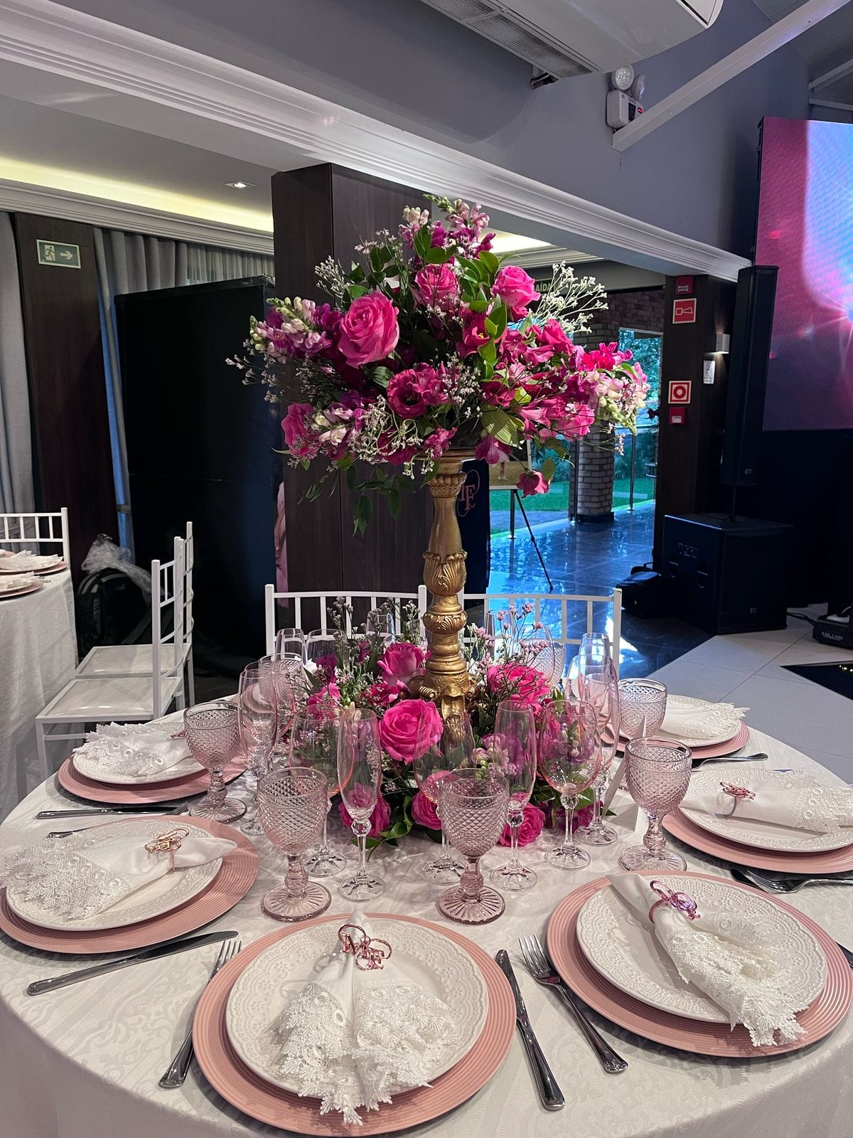 Painel de flores rosas com mesa de bolo para festa de 15 anos